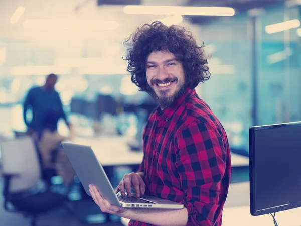 Gülümseyen erkek yazılım geliştiricisi laptop kullanıyor — Stok fotoğraf