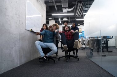 Çok ırklı iş adamları ofis sandalyelerinde yarışıyor