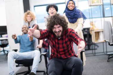 Çok ırklı iş adamları ofis sandalyelerinde yarışıyor