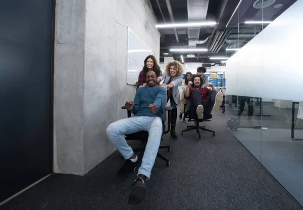Multiethnics business team racing on office chairs — Stock Photo, Image