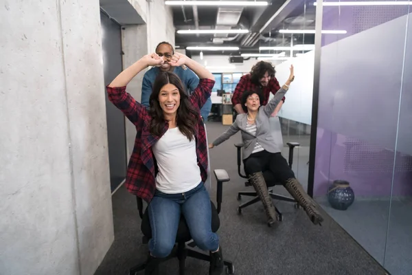 Equipo de negocios multiétnicos compitiendo en sillas de oficina —  Fotos de Stock