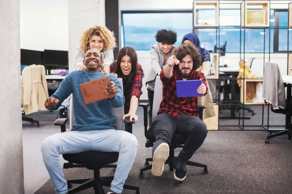 Equipo de negocios multiétnicos compitiendo en sillas de oficina —  Fotos de Stock