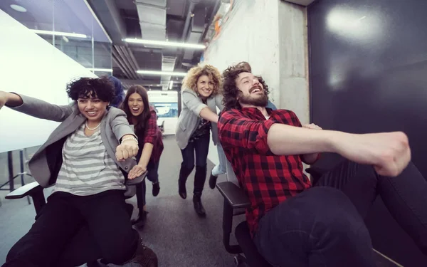 Equipe de negócios multiétnica competindo em cadeiras de escritório — Fotografia de Stock