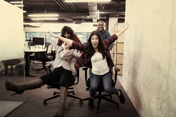 Equipe de negócios multiétnica competindo em cadeiras de escritório — Fotografia de Stock