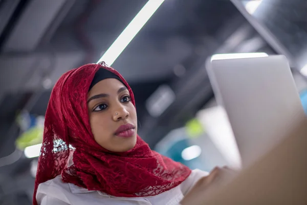 Siyah Müslüman iş kadını, dizüstü bilgisayarda çalışıyor. — Stok fotoğraf