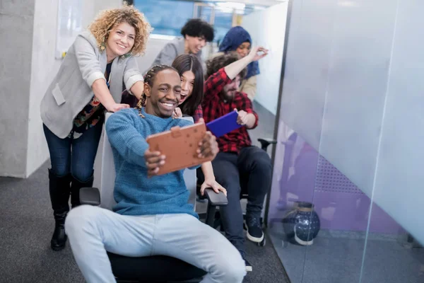 Equipo de negocios multiétnicos compitiendo en sillas de oficina — Foto de Stock