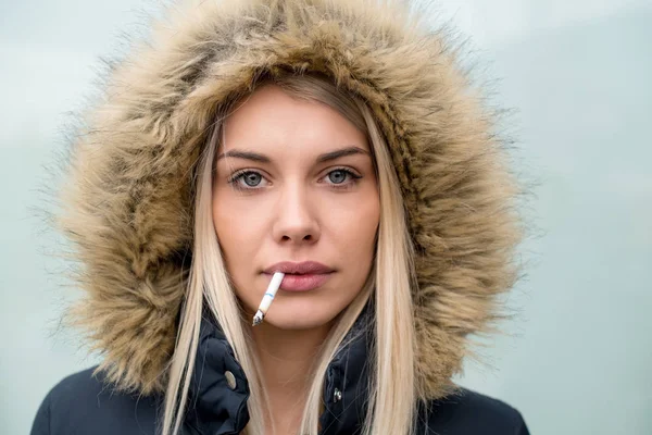 年轻的金发女孩的肖像与香烟在嘴里 — 图库照片