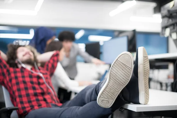 Desarrollador de software descansando con las piernas en el escritorio — Foto de Stock
