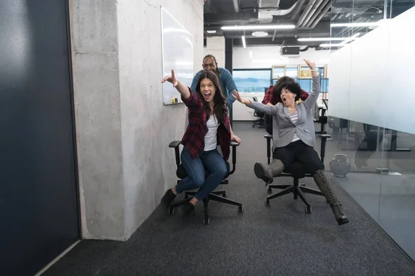 Equipo de negocios multiétnicos compitiendo en sillas de oficina —  Fotos de Stock