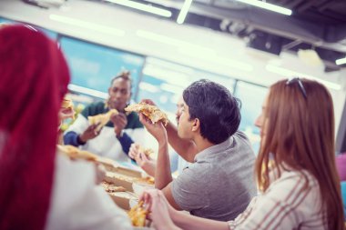 Çok ırklı iş adamları pizza yiyor.
