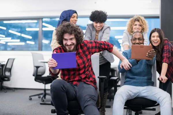 Equipo de negocios multiétnicos compitiendo en sillas de oficina —  Fotos de Stock