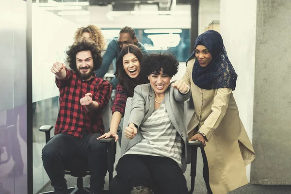 Multiethnics business team racing on office chairs — Stock Photo, Image