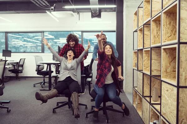 Wielonarodowy zespół biznesowy ścigający się na krzesłach biurowych — Zdjęcie stockowe