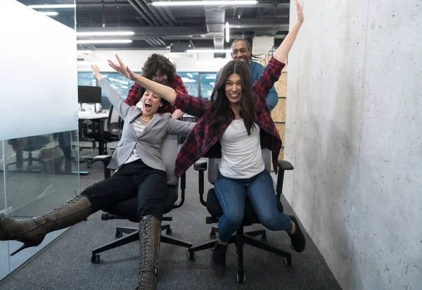 Equipo de negocios multiétnicos compitiendo en sillas de oficina —  Fotos de Stock