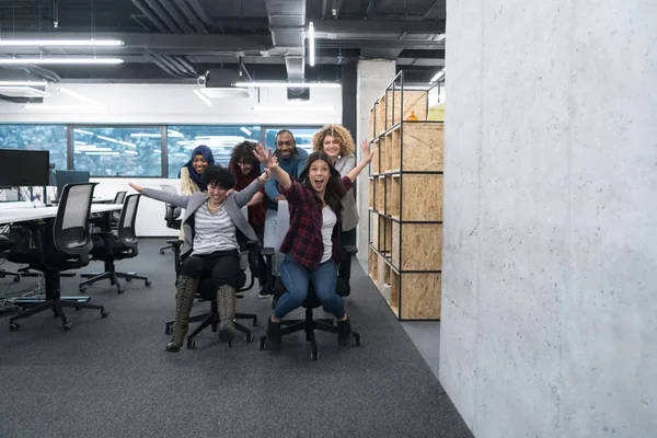 Equipo de negocios multiétnicos compitiendo en sillas de oficina — Foto de Stock