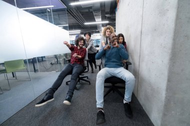 Çok ırklı iş adamları ofis sandalyelerinde yarışıyor