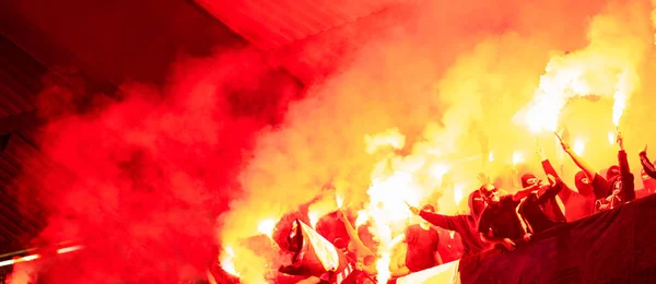 Fotbollshuliganer med mask håller facklor i brand — Stockfoto