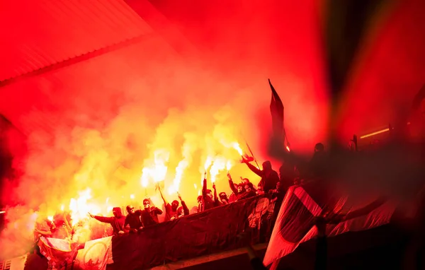 Футбольные хулиганы с маской, держащие факелы в огне — стоковое фото