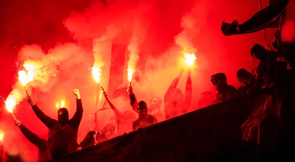 Hooligans de fútbol con máscara sosteniendo antorchas en el fuego —  Fotos de Stock