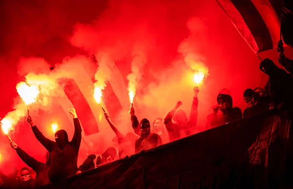 Football hooligans with mask holding torches in fire — Stock Photo, Image