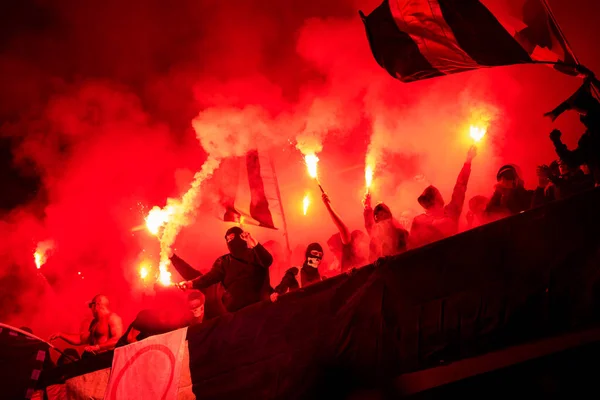 Hooligans de fútbol con máscara sosteniendo antorchas en el fuego — Foto de Stock