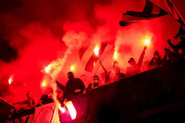 Fußball-Hooligans mit Maske halten Fackeln im Feuer — Stockfoto