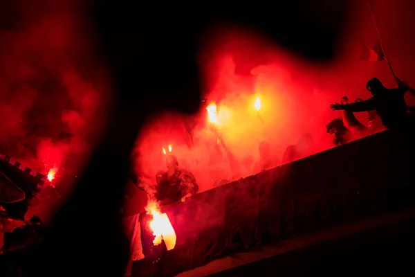 Hooligans de fútbol con máscara sosteniendo antorchas en el fuego —  Fotos de Stock