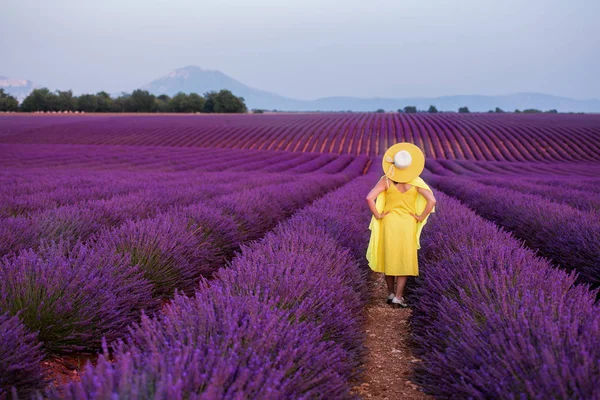 Aziatische vrouw in gele jurk en hoed op lavendel veld — Stockfoto