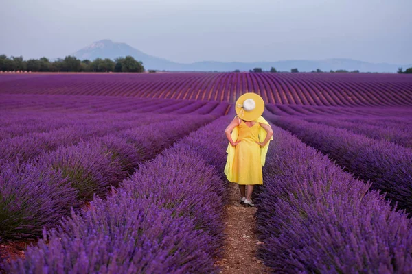 Aziatische vrouw in gele jurk en hoed op lavendel veld — Stockfoto