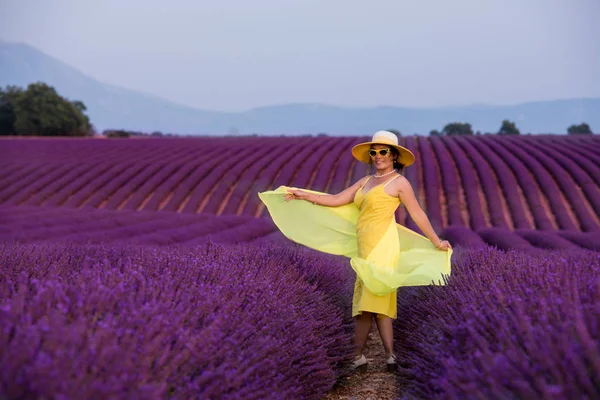 Mujer asiática vestida de amarillo y sombrero en el campo de lavanda. —  Fotos de Stock