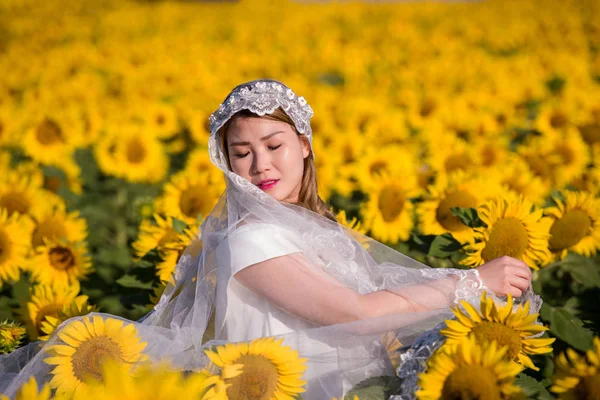 Asiatin im Sonnenblumenfeld — Stockfoto