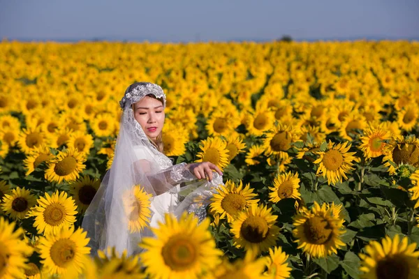 Asiatin im Sonnenblumenfeld — Stockfoto