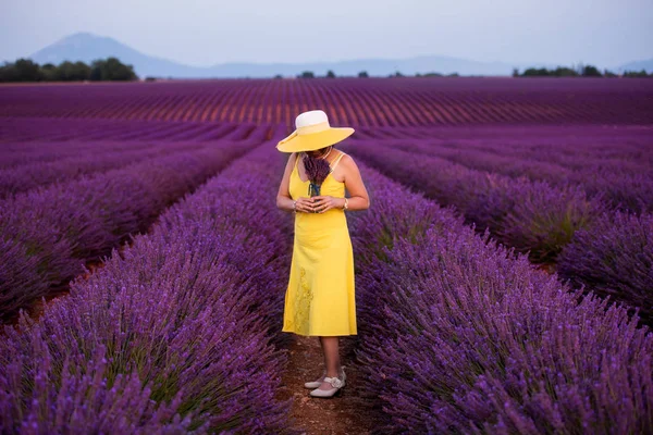 Asiatka ve žlutých šatech a klobouku na levandulovém poli — Stock fotografie