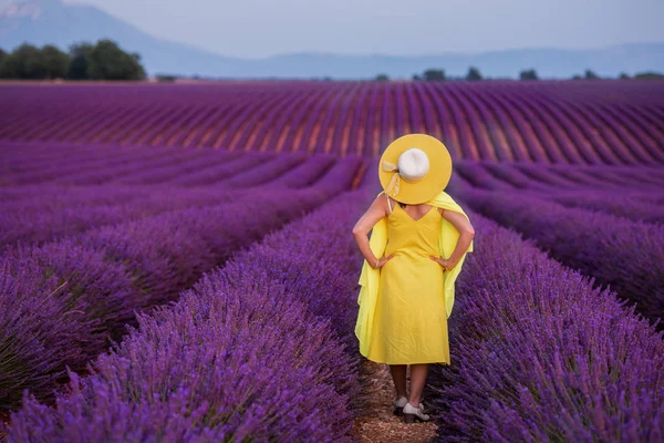 Aziatische vrouw in gele jurk en hoed op lavendel veld — Stockfoto