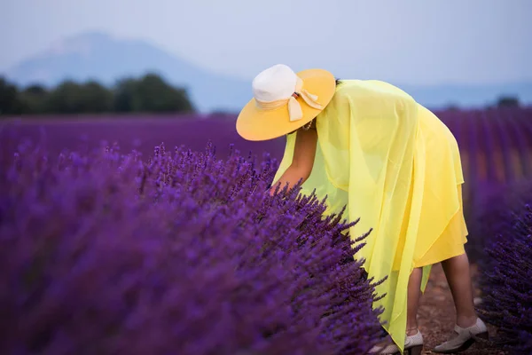 Aziatische vrouw in gele jurk en hoed op lavendel veld — Stockfoto