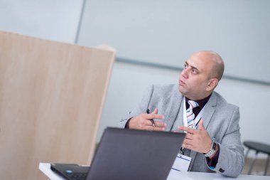 İşadamı dizüstü bilgisayarla çalışırken notlar yazıyor.