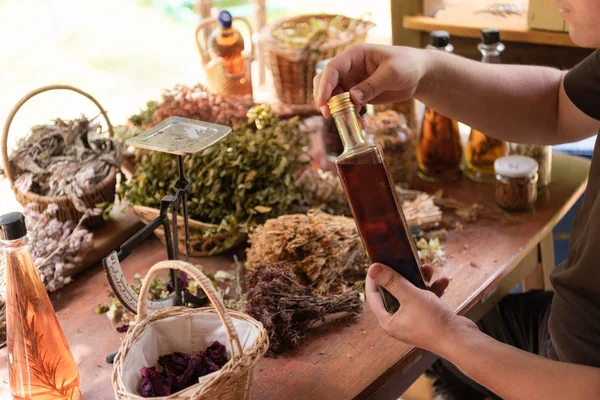 Trinkflasche in der Hand eines Kräuterkundigen — Stockfoto