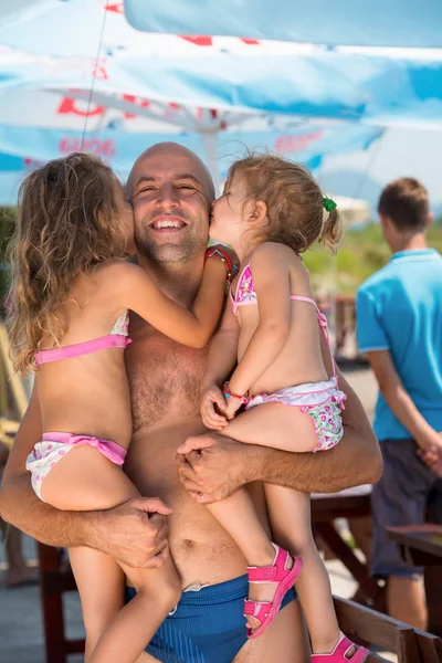 Retrato de jovem pai feliz com filhas junto ao mar — Fotografia de Stock