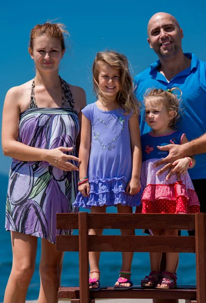 Portrait of young happy family with daughters by the sea — Stock Photo, Image