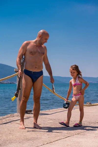 Fisherman his little daughter after underwater fishing — Stock Photo, Image