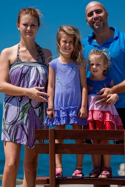 Portrait of young happy family with daughters by the sea — Stock Photo, Image