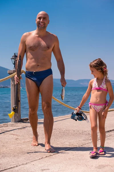 Fisherman his little daughter after underwater fishing — Stock Photo, Image