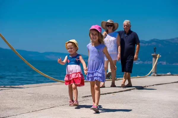 Дідусь і бабуся і онуки, що йдуть біля моря — стокове фото