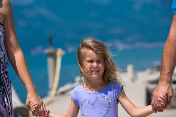 Jonge gelukkige familie wandelen door de zee — Stockfoto