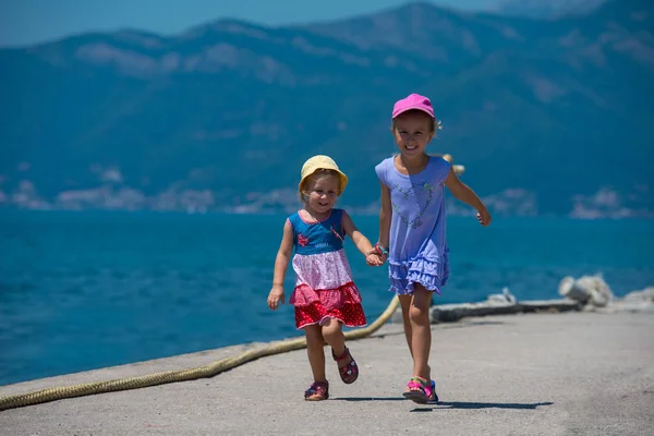 Sahil kıyısında çalışan küçük kız kardeşler — Stok fotoğraf