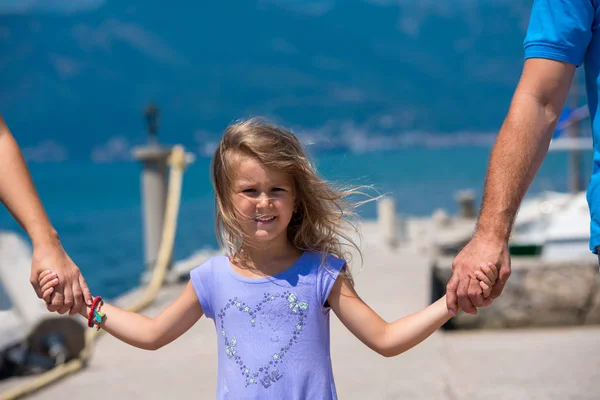 Jonge gelukkige familie wandelen door de zee — Stockfoto