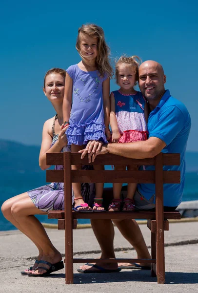 Retrato de jovem família feliz com filhas à beira-mar — Fotografia de Stock