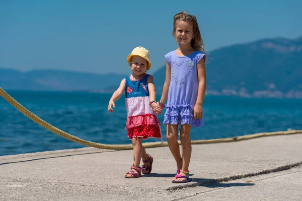 Little sisters walking on the beach coast — Stock Photo, Image