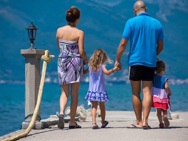 Jovem família feliz andando pelo mar — Fotografia de Stock