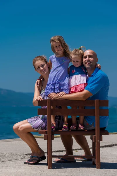 Portret van jong gelukkig gezin met dochters aan zee — Stockfoto